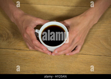 Coup de frais généraux man holding Coffee cup at table in cafeteria Banque D'Images