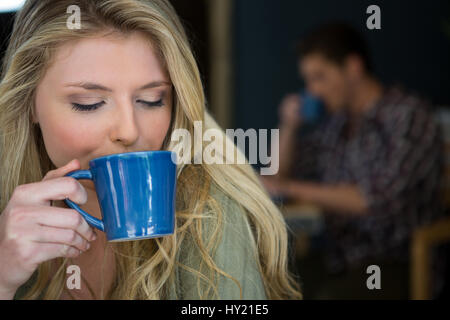 Close-up of young woman drinking coffee in cafeteria Banque D'Images
