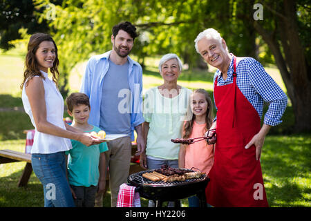 Portrait de famille multi génération debout près du barbecue dans park Banque D'Images