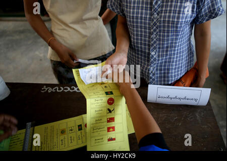 Yangon. 1er avril 2017. L'électeur reçoit un bulletin de vote lors de l'élection du Parlement européen à un bureau de scrutin à Yangon le 1 avril 2017. Myanmar le samedi a tenu le parlement pluraliste d'une élection partielle. Credit : U Aung/Xinhua/Alamy Live News Banque D'Images