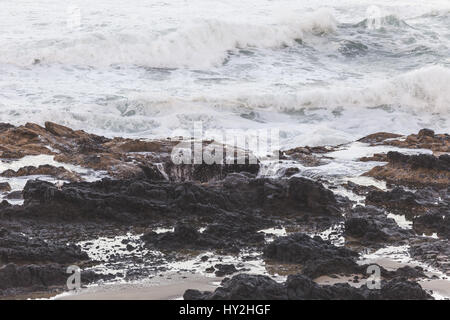 Vagues se brisant sur le rivage au coucher du soleil. Thor est bien, Cape Perpetua, Oregon, USA. Banque D'Images