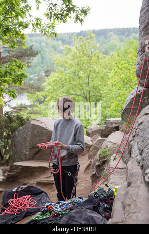 La Suède, Vastergotland, Boy (14-15) avec des cordes d'escalade en montagne