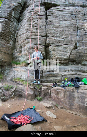 La Suède, Vastergotland, Boy (14-15) avec des cordes d'escalade au pied du rocher