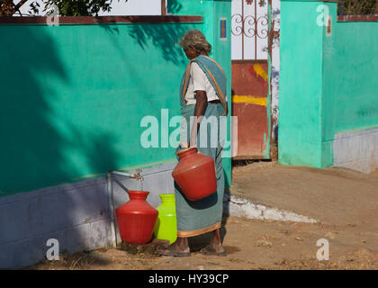 Vieille Femme eau de remplissage container,Inde. Banque D'Images