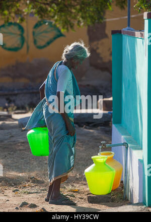 Vieille Femme eau de remplissage container,Inde. Banque D'Images