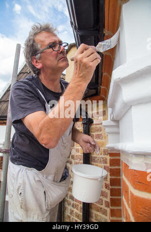 Peintre et décorateur peinture l'extérieur de maison victorienne dans le nord de Londres, UK Banque D'Images