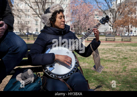 Femme afro-américaine à jouer du banjo dans un parc public, USA Banque D'Images