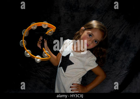 Jeune fille avec instrument holding tambourin Banque D'Images