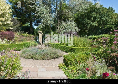 Une vue de la statue de jeune fille timide dans le jardin de roses à Burrow Farm Gardens, également connu sous le nom de East devons Secret Garden, près de Axminster, Devon, England, UK Banque D'Images