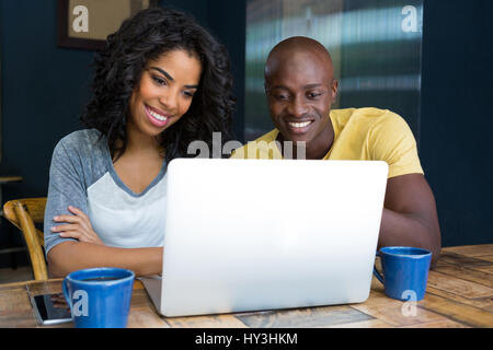 Smiling young couple at table in coffee shop Banque D'Images