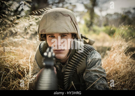 Portrait de soldat militaire visant avec un fusil dans boot camp Banque D'Images