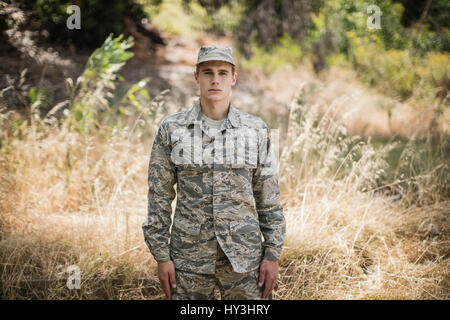 Portrait de soldat militaire debout dans l'herbe dans boot camp Banque D'Images