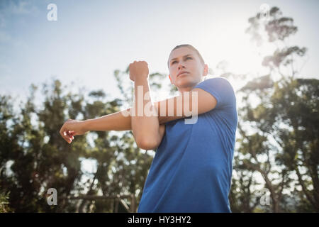 Fit woman performing exercice s'étendant dans boot camp Banque D'Images