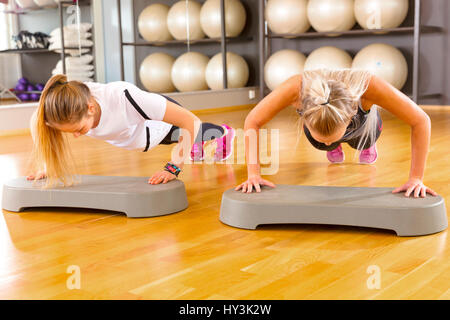Deux amies, faisant confiance au gymnase Pushups Banque D'Images