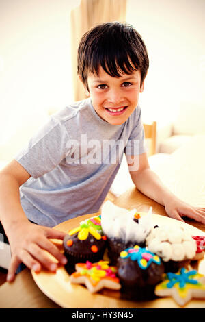 Happy boy eating confiseries colorées à la maison Banque D'Images