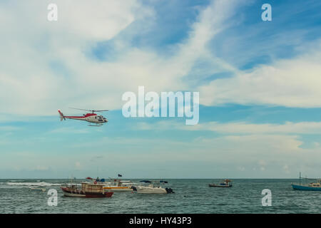 Vol en hélicoptère dans un ciel bleu avec des nuages gonflés sur la mer pleine de pêcheurs, bateaux, navires et bateaux Banque D'Images