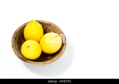 Les citrons dans un bol en bois véritable artisan naturel isolé en fond blanc - vue d'en haut Banque D'Images