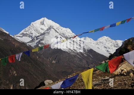 Montagnes enneigées et les drapeaux de prières. Scène de printemps près de Namche Bazar, Everest Parc National. Banque D'Images