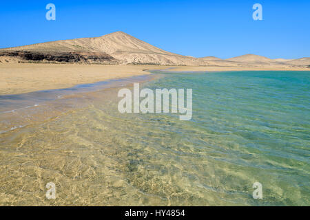 Belle plage sur la côte sud de Fuerteventura et des dunes de sable à l'arrière-plan, Îles Canaries, Espagne Banque D'Images