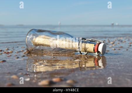 Message dans une bouteille échouée sur la plage Banque D'Images