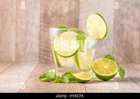 Boire pendant des jours chauds d'été. Fresh lime et citron limonade à la menthe dans un verre sur un bureau en bois Banque D'Images