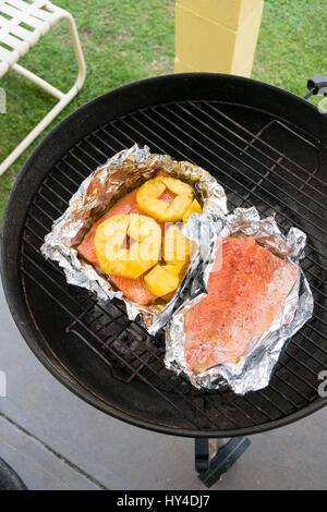 Charcoal grill avec du saumon et d'ananas sur des charbons ardents sur le barbecue dans Oahu Hawaii. Banque D'Images