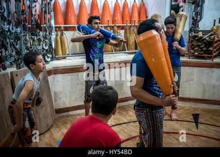 Les hommes et les garçons iraniens avec formation clubs en bois en Zoorkhaneh (Maison de la Force), gymnase traditionnel de Yazd, ville de la province de Yazd Iran Banque D'Images