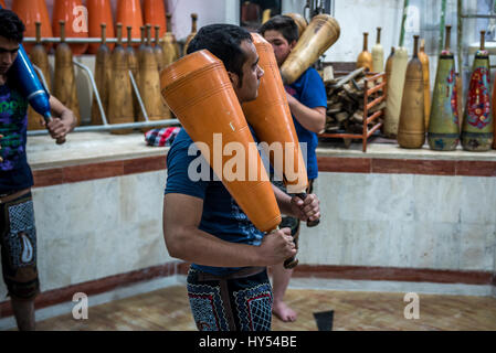 Les hommes et les garçons iraniens avec formation clubs en bois en Zoorkhaneh (Maison de la Force), gymnase traditionnel de Yazd, ville de la province de Yazd Iran Banque D'Images