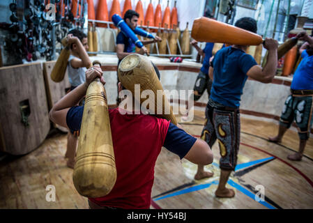 Les hommes et les garçons iraniens avec formation clubs en bois en Zoorkhaneh (Maison de la Force), gymnase traditionnel de Yazd, ville de la province de Yazd Iran Banque D'Images