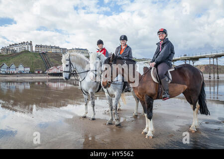 Trois femmes à cheval sur la plage de Nice en Angleterre du Nord-Est, Royaume-Uni Banque D'Images