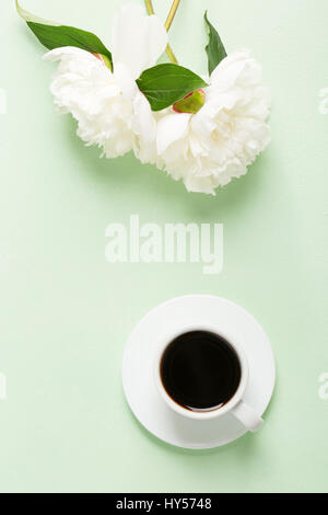 Tasse de café et de fleurs (pivoines) sur le tableau vert clair. Banque D'Images