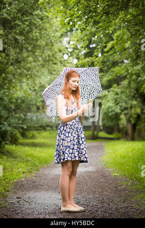 La Finlande, Pirkanmaa, Tampere, femme portant robe debout avec parapluie dans park