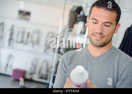 Man looking at equestrian produit en bouteille plastique Banque D'Images