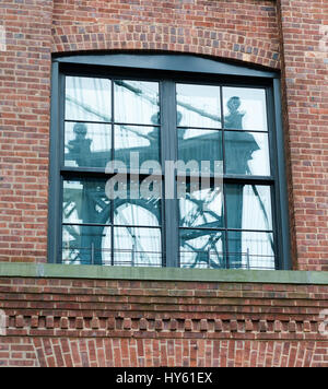 Reflet de Manhattan Bridge capturés dans un bâtiment en brique fenêtre dans Dumbo, Brooklyn, New York. Banque D'Images