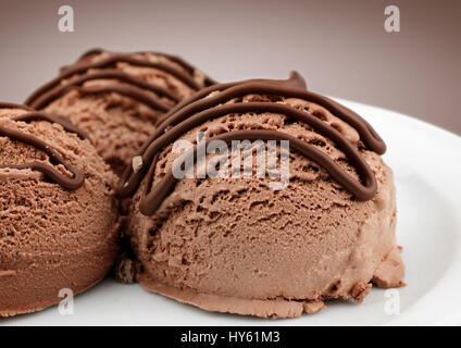 Brown boules de glace avec une sauce au chocolat, macro Banque D'Images