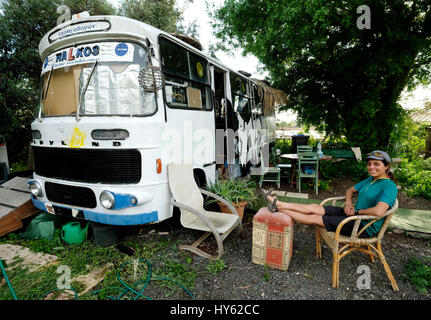 Backpacker Justine est d'un séjour dans un vieux bus à Paphos,Chypre. L'autobus a été fourni à titre gracieux par un jeune à surfers. table Chypriote Banque D'Images