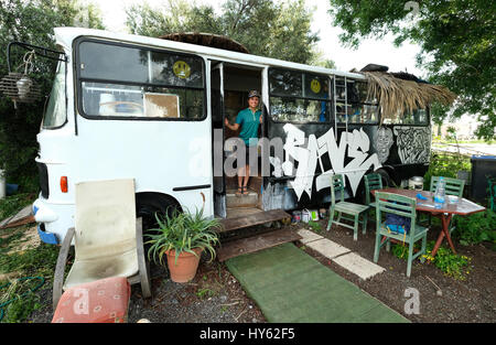 Backpacker Justine est d'un séjour dans un vieux bus à Paphos,Chypre. L'autobus a été fourni à titre gracieux par un jeune à surfers. table Chypriote Banque D'Images