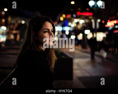 Une jeune fille assise sur un banc à l'animation de la 3rd Street Promenade de Santa Monica, peut-être que l'attente de quelqu'un ou avoir juste de temps seul. Banque D'Images