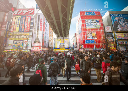 TOKYO, JAPON - 2 janvier 2017 : la foule passer en-dessous des panneaux colorés à Akihabara. Historique Le quartier de l'électronique s'est transformé en un centre commercial pour Banque D'Images