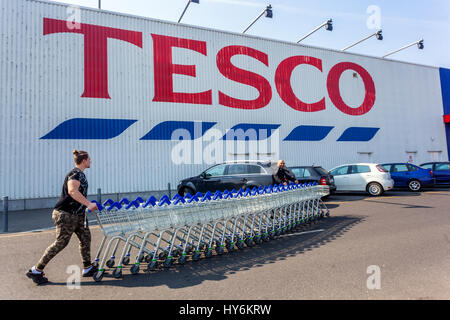 Femme poussant des chariots Tesco magasin chariots signe large de vue de supermarché, logo, République tchèque Banque D'Images