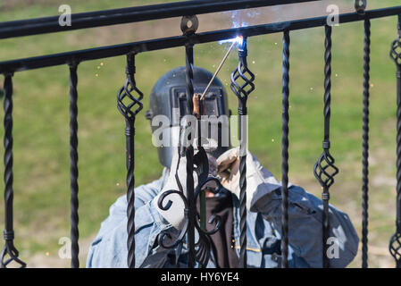 Un travailleur welding metal mains courantes dans les escaliers. En fer forgé. Maison privée. L'Ukraine. Banque D'Images