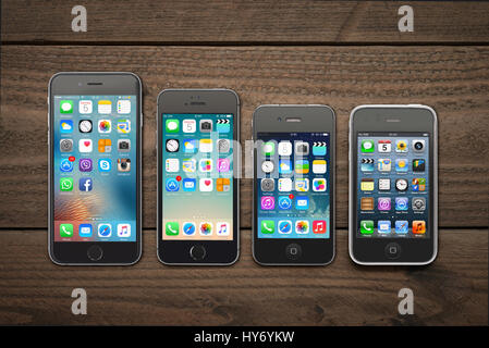 Kiev, Ukraine - Mars 05, 2016 : vue avant d'un espace couleur gris Les iphone 6, 5s, 4 et 3gs génération montrant les écrans d'accueil sur fond de bois. Banque D'Images