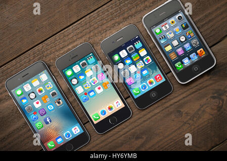 Kiev, Ukraine - Mars 05, 2016 : vue avant d'un espace couleur gris Les iphone 6, 5s, 4 et 3gs génération montrant les écrans d'accueil sur fond de bois. Banque D'Images