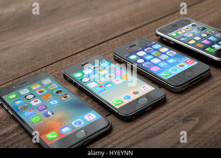 Kiev, Ukraine - Mars 05, 2016 : vue avant d'un espace couleur gris Les iphone 6, 5s, 4 et 3gs génération montrant les écrans d'accueil sur fond de bois. Banque D'Images