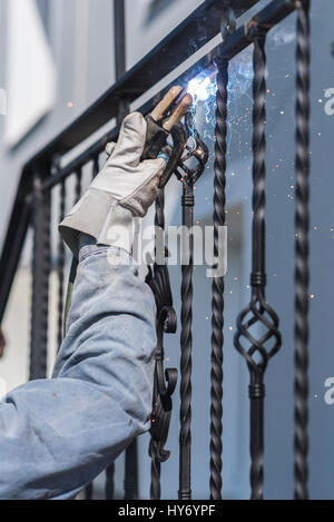 Un travailleur welding metal mains courantes dans les escaliers. En fer forgé. Maison privée. L'Ukraine. Banque D'Images