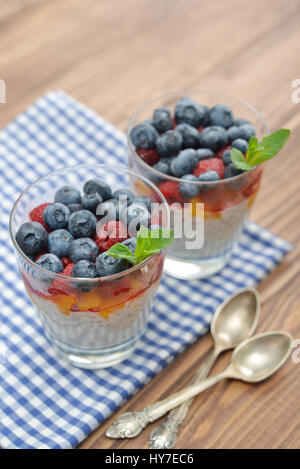 Au lait avec amandes et noix, yogourt et fruits frais en verre sur fond de bois Banque D'Images