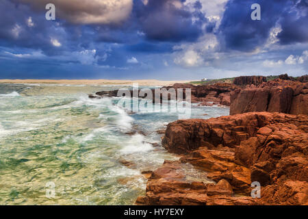 La transition vers la côte rocheuses et de dunes de sable à la plage près de sunrise orageux Port Stephens, NSW, Australie. Banque D'Images