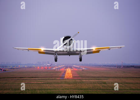 Avion rétro voler jusqu'à décoller piste de l'aéroport au crépuscule Banque D'Images