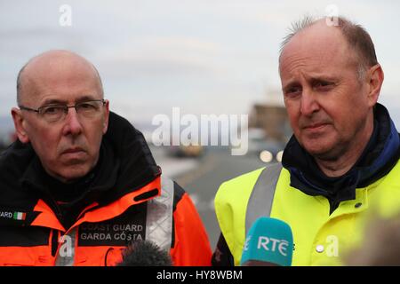 Gerard O'Flynn (à gauche) responsable des opérations de recherche et de sauvetage avec la Garde côtière irlandaise et l'inspecteur en chef des accidents aériens, Jurgen Whyte, parler aux médias après l'arrivée du Granuaile dans Blacksod avec l'épave d'hélicoptère de garde-côtes 116 sauvetage à bord, comme les recherches sont à poursuivre pour deux membres d'équipage de la Garde côtière irlandaise après une opération majeure de lever leur hélicoptère à partir de la mer n'a pas réussi à les localiser. Banque D'Images