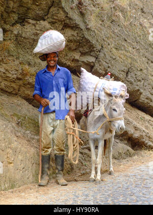 Un Cabo Verdienne agriculteur et son âne, diviser la charge. Santo Antao, République de Cabo Verde, l'Afrique. Banque D'Images